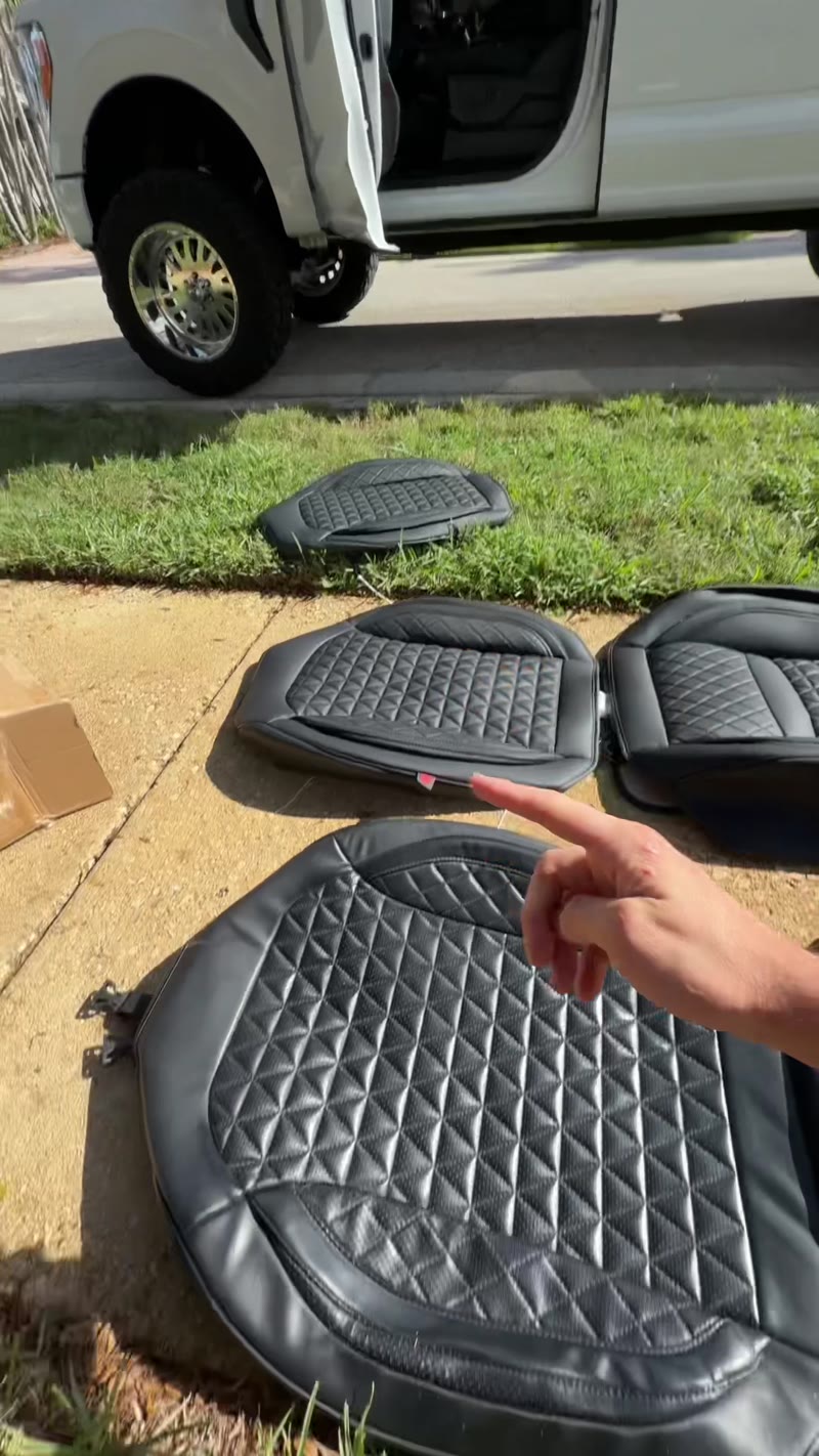 Seat covers laid out next to a white truck before the install